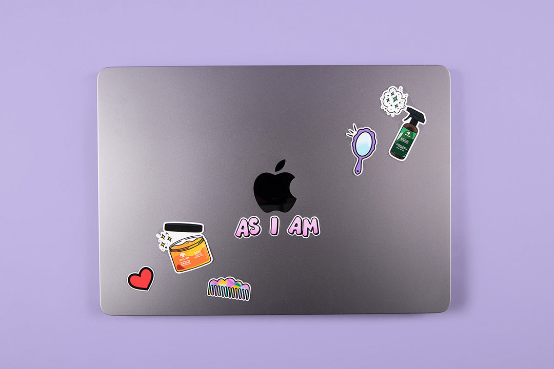 Aufkleber der Marke As I Am auf einem Laptop - ein Bild im Querformat, das freche, verspielte Aufkleberdesigns zeigt, die den Stolz und die Individualität der Locken widerspiegeln und dem technischen Zubehör Persönlichkeit verleihen.