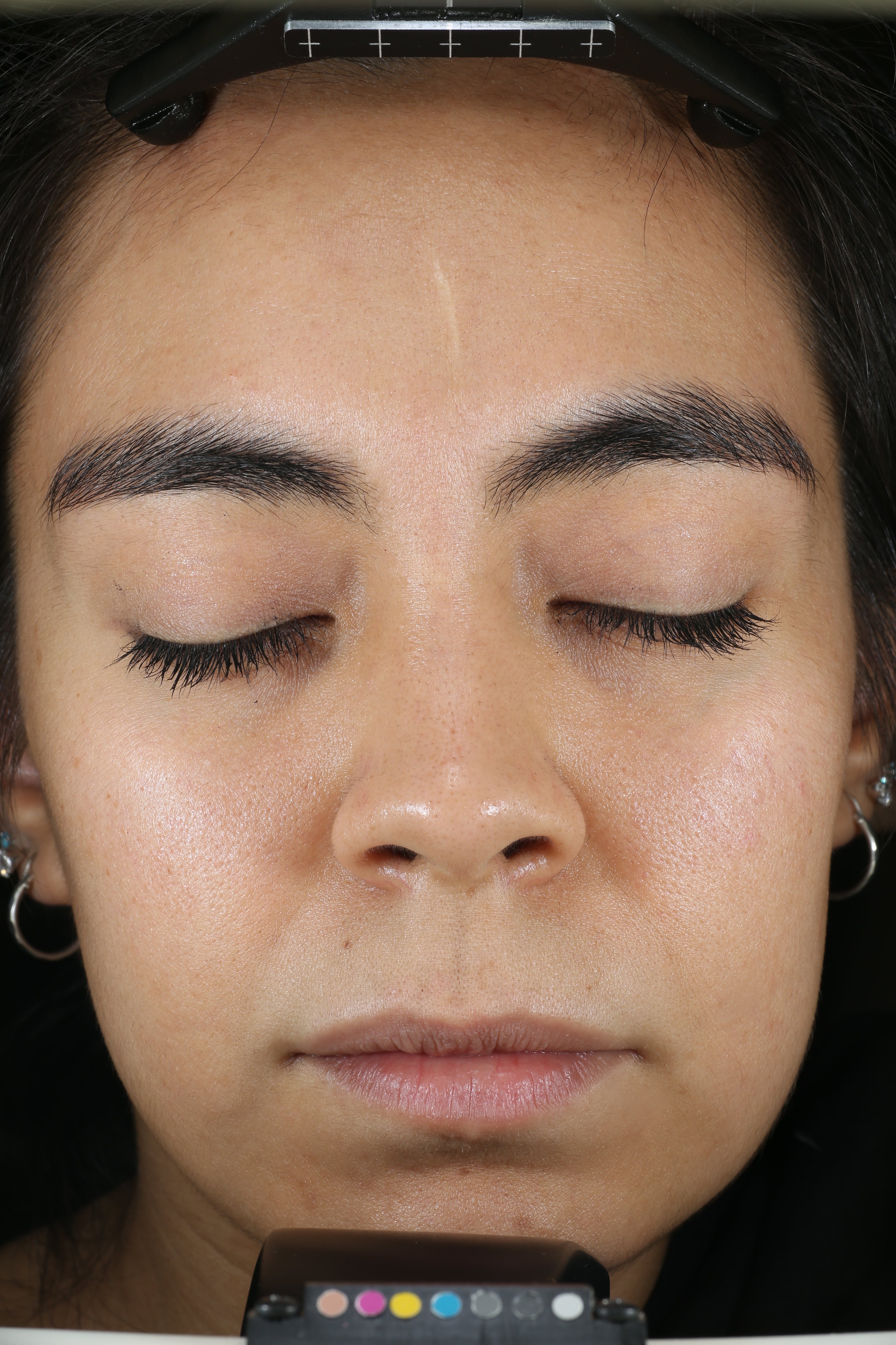 Nahaufnahme des Gesichts einer Person mit geschlossenen Augen, auf dem die Hautstruktur und -farbe zu sehen sind.