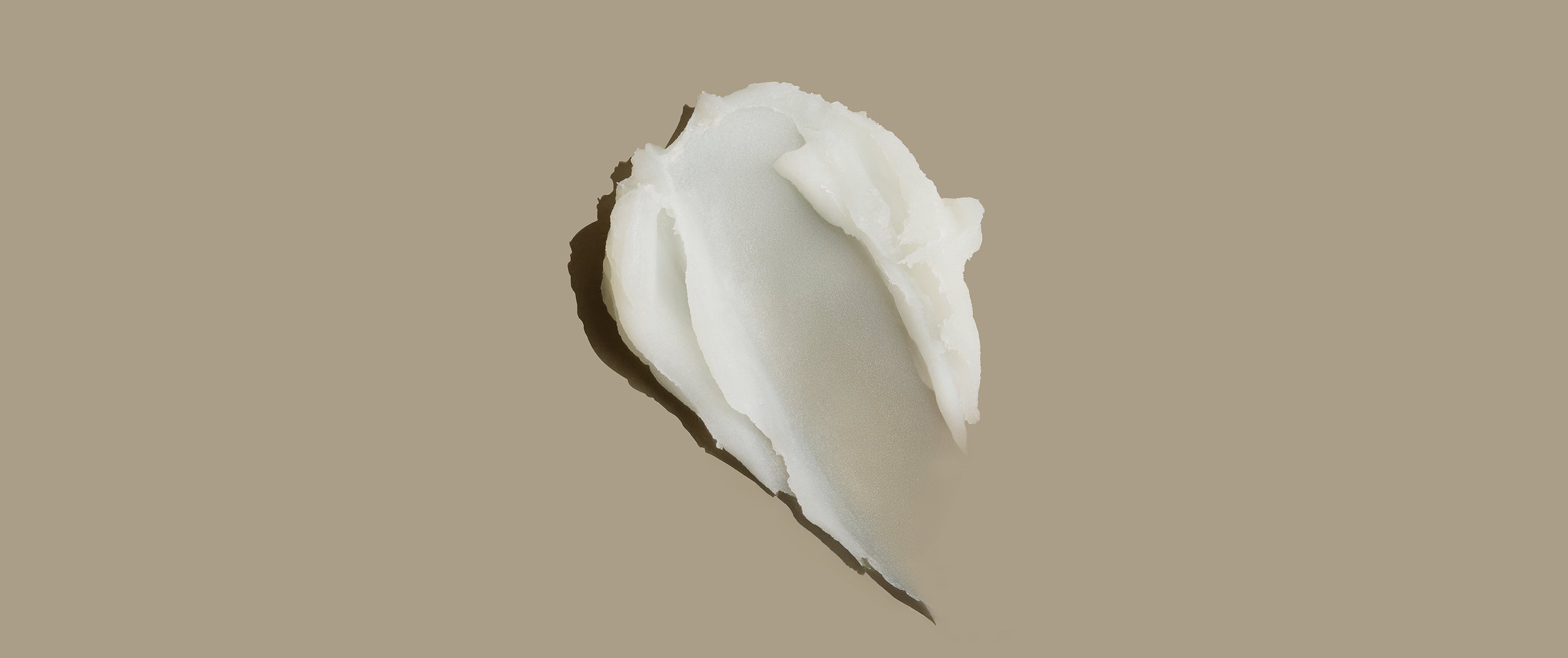 Die Nahaufnahme der Textur des AS I AM Rosemary Wax Stick zeigt einen geschmeidigen, cremigen Balsam mit halbmattem Finish, der für ein elegantes Styling und die Kontrolle von Kräuselungen entwickelt wurde.